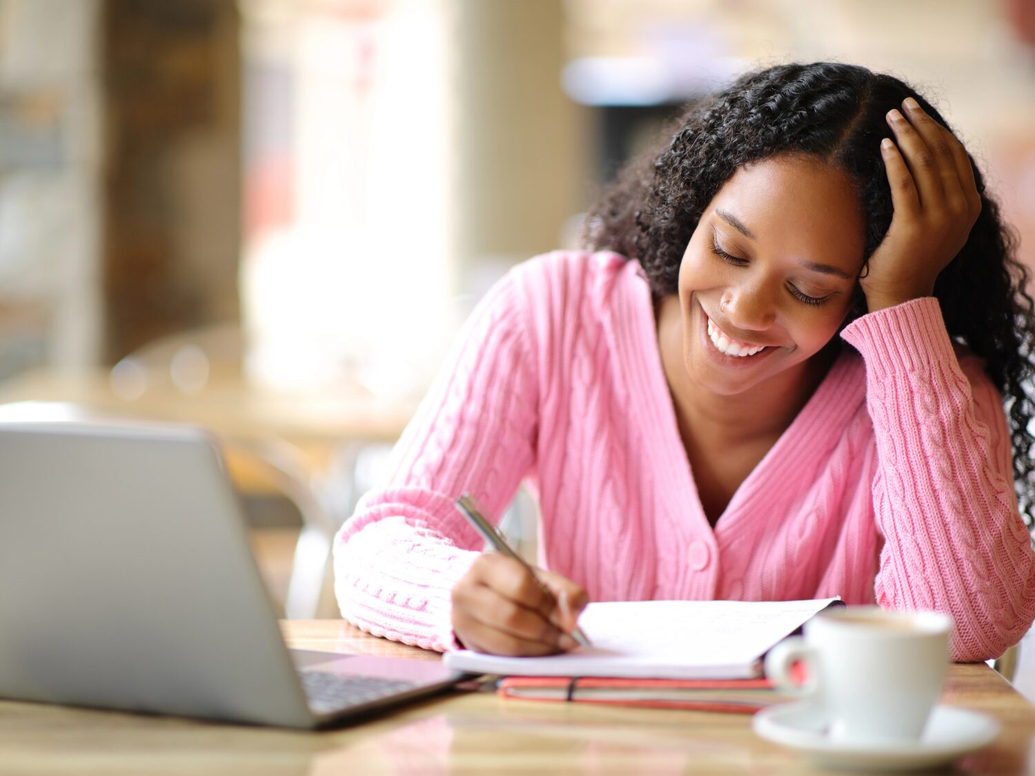 Étudiante rédigeant un article dans un café